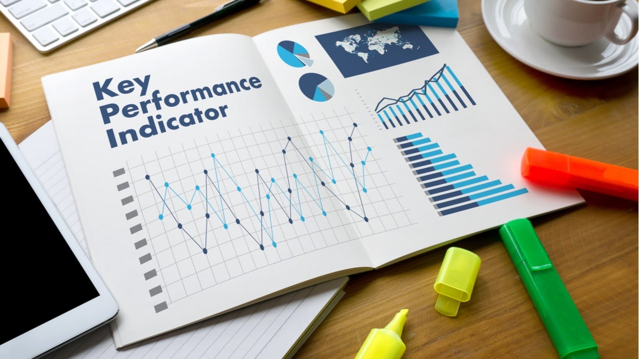 texto key performance indicator escrito en un cuaderno abierto encima de un escritorio